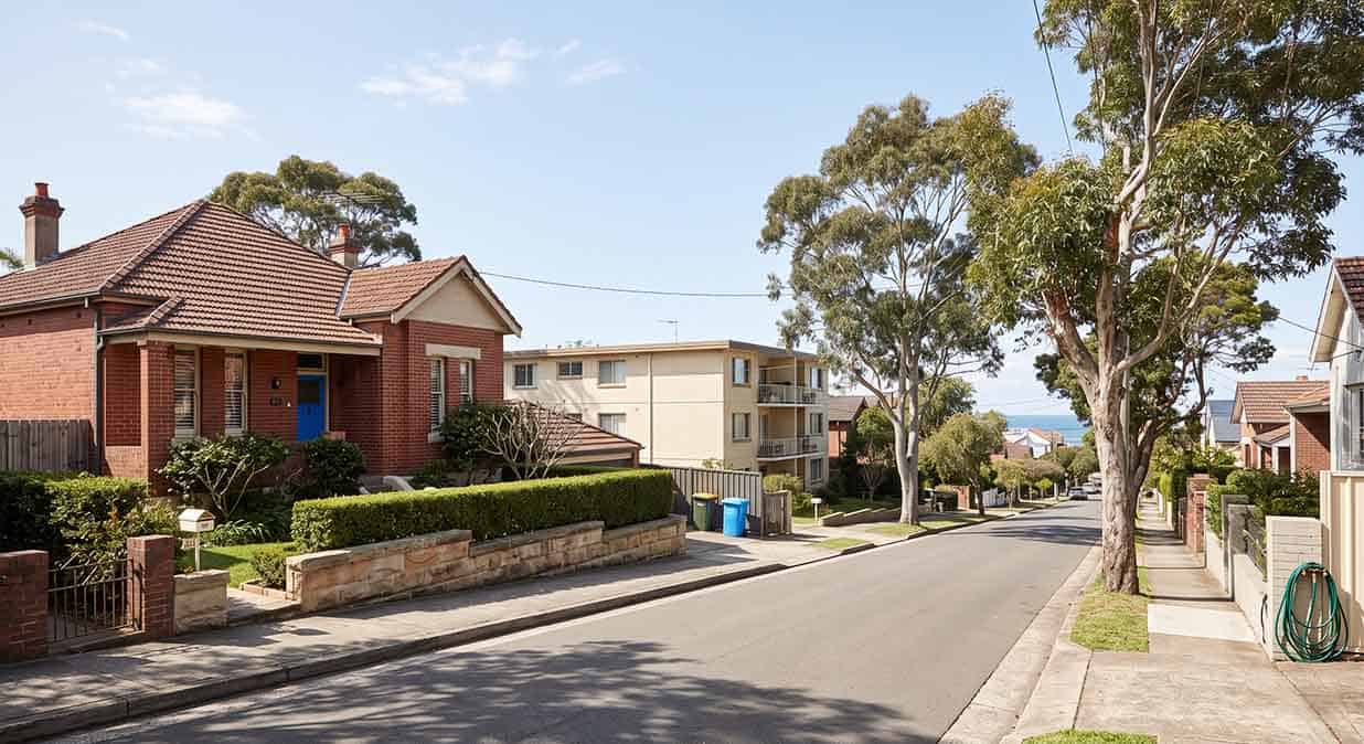 A residential street in Sydney's eastern suburbs showing a Federation terrace and a low apartment block, the mix of homes PestOz treats.